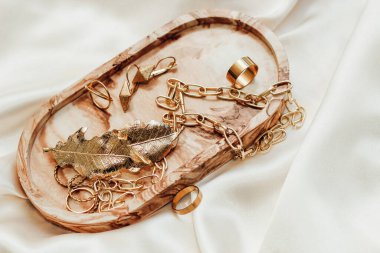 Alçıtaşı mermer süsleme standı ve ipek standın arka planında altın süsleme.