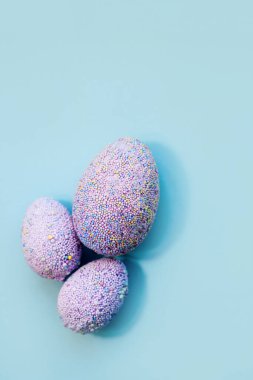 Pastel arka planda mor Paskalya dekoratif yumurtaları..