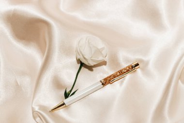 İpek bej arkaplanda beyaz gül, altın kalemle, metin için boşluk.