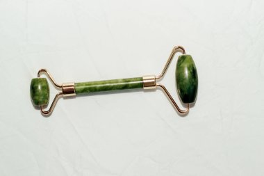 Masaj taşı yeşim taşı kazıyıcı ve yüz kaydırma lambası arka planı.