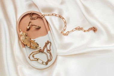 Alçıtaşı mermer süsleme standı ve ipek standın arka planında altın süsleme.