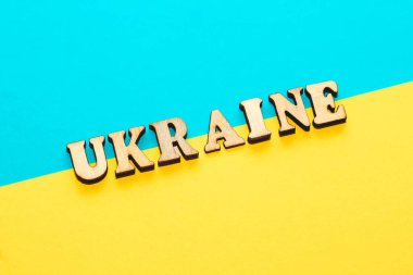 Ukrayna 'nın mavi-sarı bayrağının mukavva arka planında tahta yazılar.