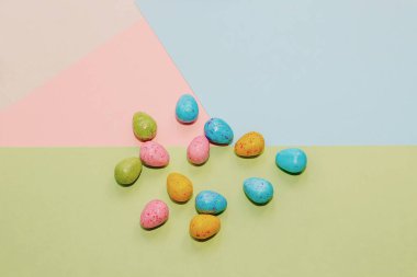 Pastel arka planda çok renkli Paskalya dekoratif yumurtaları.