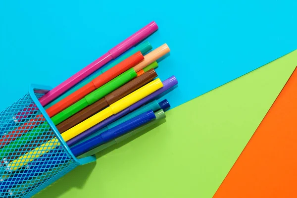 Çok renkli karton kağıdın arka planında duran sarı kağıt uçlu keçeli kalemler..