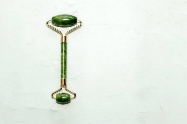 Masaj taşı yeşim taşı kazıyıcı ve yüz kaydırma lambası arka planı.