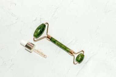 Masaj taşı gouache kazıyıcı ve kozmetik kremli yüz silindiri..