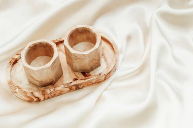 İpek standın arka planında alçıtaşı mermer dekoratif duruş.