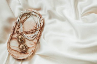 Alçıtaşı mermer süsleme standı ve ipek standın arka planında altın süsleme.