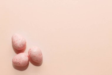 Kırmızı çikolatalı paskalya şekerli yumurtalar kağıttan arka planda.