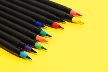 Çok renkli kağıt üzerinde keçeli kalemler ve fırçalar. Çok renkli karton kağıtlar..