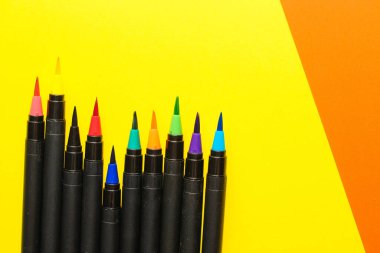 Çok renkli kağıt üzerinde keçeli kalemler ve fırçalar. Çok renkli karton kağıtlar..