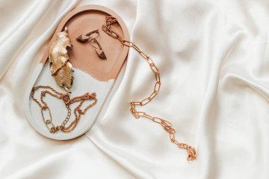 Alçıtaşı mermer süsleme standı ve ipek standın arka planında altın süsleme.