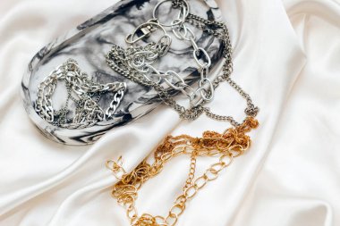 Alçıtaşı mermer süsleme standı ve ipek standın arka planında gümüş ve altın mücevherler.