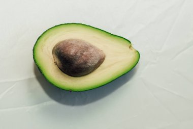 Açık arkaplanda yeşil avokado, sağlıklı besin konsepti.