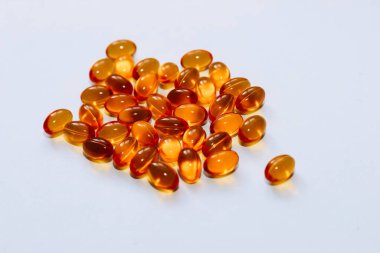 Beyaz arka planda altın jöle kabuklu balık yağı hapları..