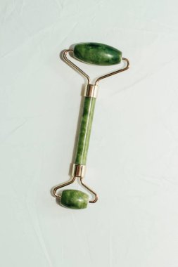 Masaj taşı yeşim taşı kazıyıcı ve yüz kaydırma lambası arka planı.