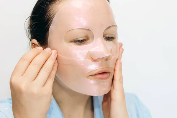 Girl makes a mask for the whole face on problem skin.