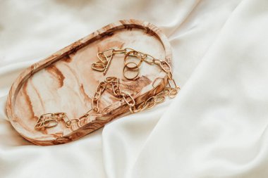 Alçıtaşı mermer süsleme standı ve ipek standın arka planında altın süsleme.