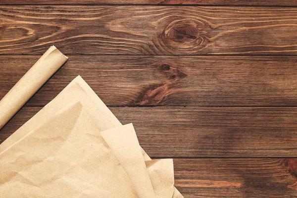 Tahta bir arka planda paket paketlemek için rulo halinde Kraft kağıdı.