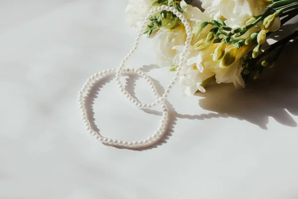 Pulseras Blancas Con Cuentas Perlas Sobre Fondo Blanco Con Flores —  Fotos de Stock
