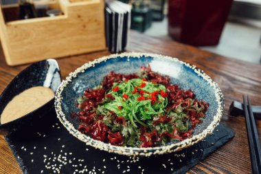 Ceviz soslu ve tabakta susam tohumlu yosun salatası.