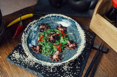 Seaweed wakame ahtapot chili susam bir tabak ve çubuk içinde