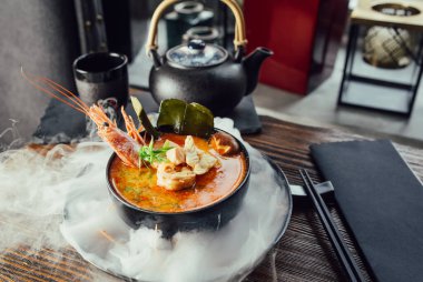 Karides, çubuk ve çaydanlıklı Tom yum çorbası.