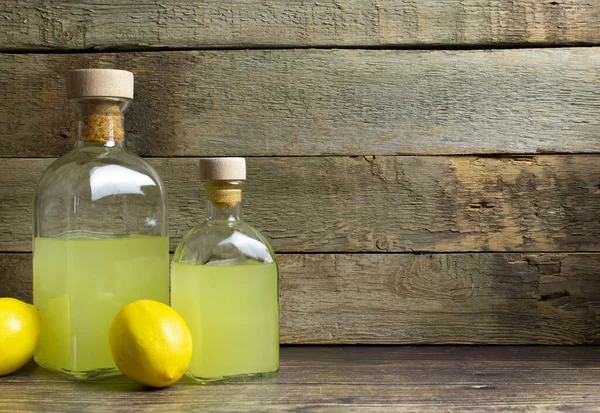 Zwei Flaschen Limoncello Und Zitronen Mit Kopierraum Auf Rustikalem Holzgrund — Stockfoto