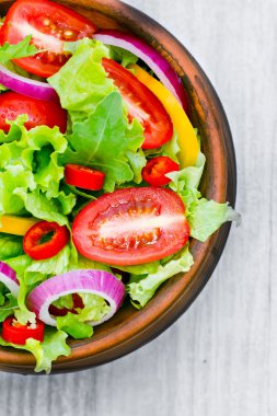 ahşap arka plan üzerine bir kase taze salata