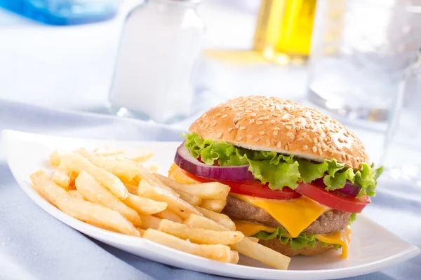 Hamburguesa y papas fritas en el plato . — Foto de Stock