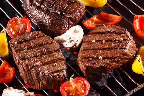 Beef steak on a barbecue grill with vegetables — Stock Photo, Image