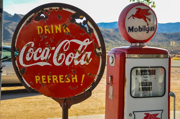 复古燃气泵和生锈的可口可乐公司签署在 66 号公路上 — 图库照片