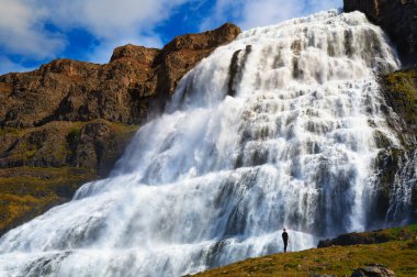 İzlanda 'daki Westfjords yarımadasındaki Dynjandi şelalesinde duran kişi.