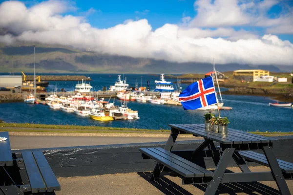 Bandiera dell'Islanda posta su un tavolo da ristorante con un porto sullo sfondo — Foto Stock