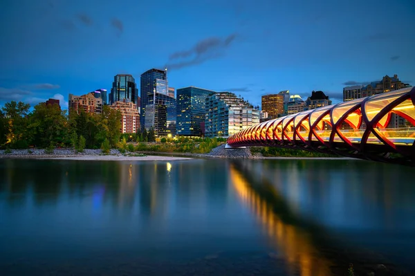 Friedensbrücke über den Bow River und Calgarys Skyline bei Nacht fotografiert — Stockfoto