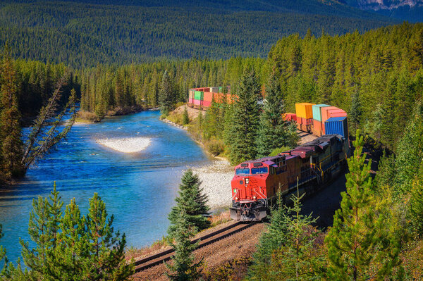 Train passing through Morants Curve in bow valley, Canada