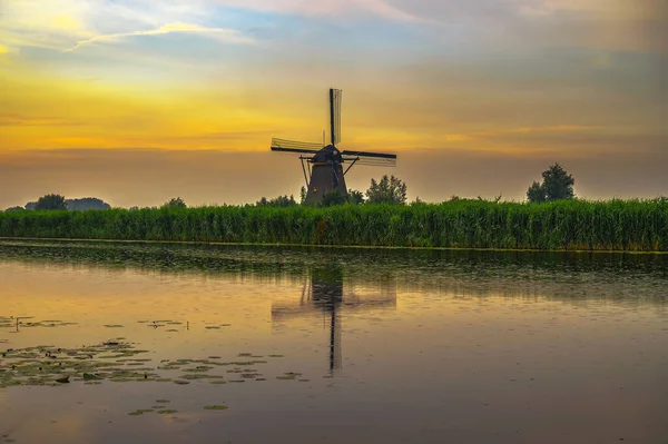 Moinho de vento holandês velho ao pôr do sol em Kinderdijk, Países Baixos — Fotografia de Stock