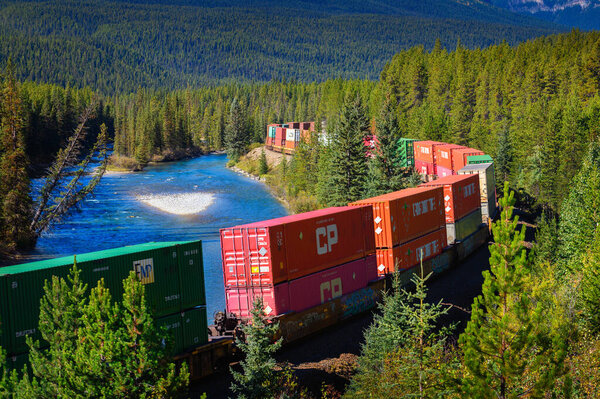 Freight train passing through Morants Curve in bow valley, Canada