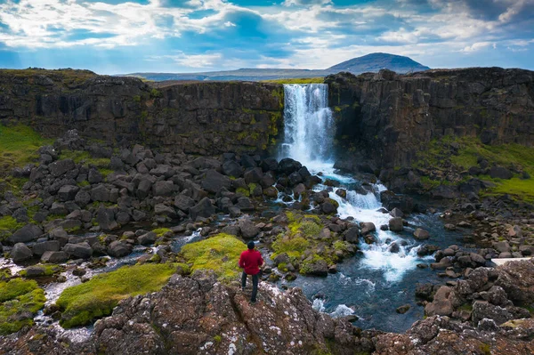 İzlanda 'da Oxarafoss şelalesine bakan bir turist — Stok fotoğraf