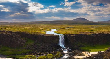 İzlanda 'da turistlerle Oxarafoss şelalesinin hava manzarası
