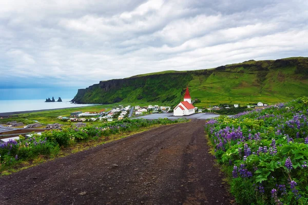Грязная дорога к деревне Вик и ее лютеранской церкви в Исландии — стоковое фото