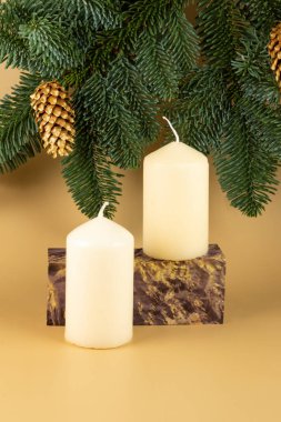 Dengeli ahşaptan yapılmış bir podyum ve sarı zemininde mumlar olan bir Noel ağacı. Kozmetik ürünlerinin tanıtımı için düzenleme.