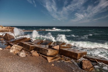 Beton tetrapodlarla erozyondan kıyıları güçlendirmek. Beton bloklu deniz kıyısı. Su elementi. Dalgalar betonda kırılır.