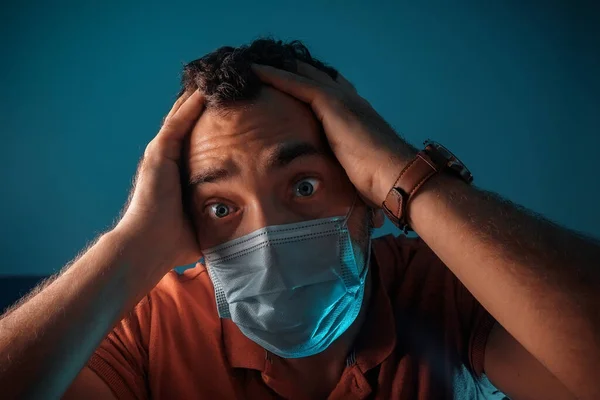 一个带着医疗面罩带着蓝色背景的晒黑了的男人传染性病毒性疾病 个人卫生用品 — 图库照片
