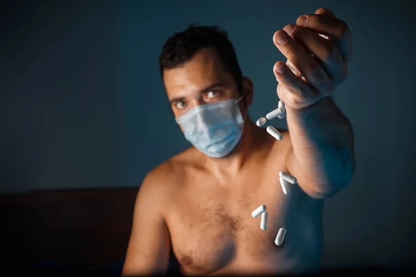 Een Gebruinde Man Met Een Medisch Masker Veel Witte Pillen — Stockfoto