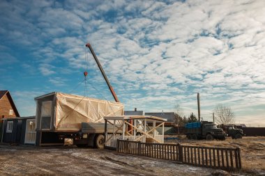 Modüler çerçeveli bir evin teslimatı ve kurulumu. Küçük evlerin iskeleti. Modüler konut inşaatı. Senin evin. Ucuz bir ev..