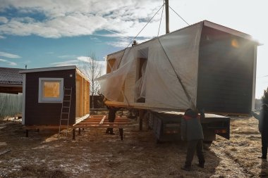 Modüler çerçeveli bir evin teslimatı ve kurulumu. Küçük evlerin iskeleti. Modüler konut inşaatı. Senin evin. Ucuz bir ev..