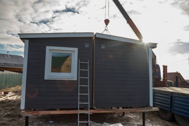 Modüler çerçeveli bir evin teslimatı ve kurulumu. Küçük evlerin iskeleti. Modüler konut inşaatı. Senin evin. Ucuz bir ev..
