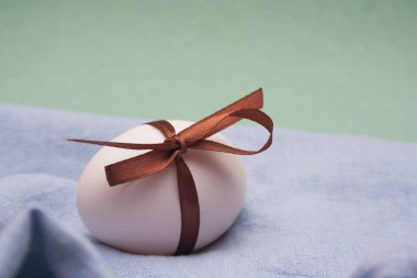 Fotokopi alanı olan mavi yeşil arkaplanlı beyaz bir Paskalya yumurtası. Dünya Yumurta Günü