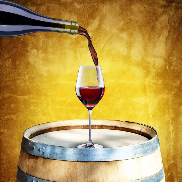 Red wine pour from bottle to glass on wood barrel — Stock Photo, Image